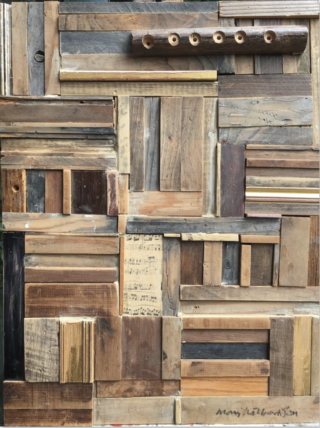 An assemblage of natural salvaged wood by Morris Nathanson incorporating a turned flute and a fragment of sheet music